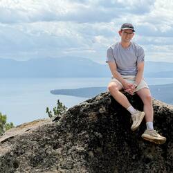 Joscha sitting on a rock above a lake
